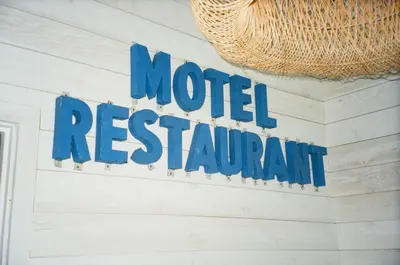 a sign for a motel restaurant hanging on a wall at The Surfside Hotel in Stratford
