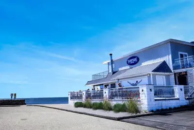 a seafood restaurant with the ocean in the background at The Surfside Hotel in Stratford