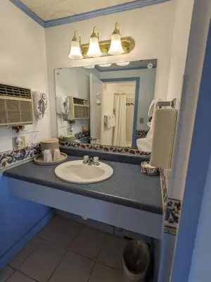 a bathroom with a sink and a mirror at Bennington Motor Inn in Bennington