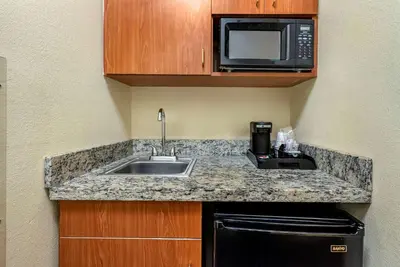 a kitchen with a sink and a microwave at Comfort Suites Newark - Harrison in Newark