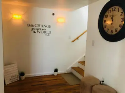 a room with a clock on the wall and stairs at UPDATED Amazing Bi -Level Condo minutes from water views of New York City in North Bergen