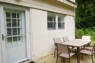 a patio with a table and chairs next to a door at Contemporary 3 Bedroom Apt with Sauna in Woods in Armonk