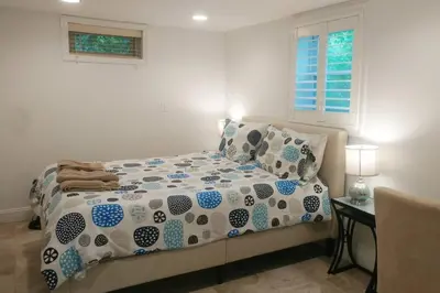 a bedroom with a bed and a table and a window at Contemporary 3 Bedroom Apt with Sauna in Woods in Armonk
