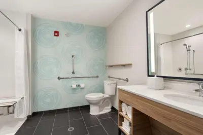 a bathroom with a toilet and a sink and a mirror at Tru By Hilton Albany Airport, Ny in Latham