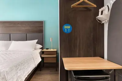 a small bedroom with a bed and a table at Tru By Hilton Albany Airport, Ny in Latham