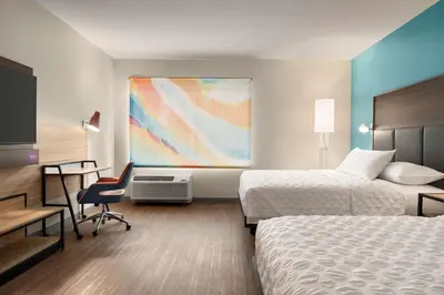 a hotel room with two beds and a desk at Tru By Hilton Albany Airport, Ny in Latham