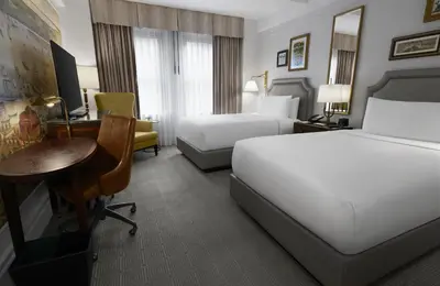 a hotel room with two beds and a desk at InterContinental New York Barclay Hotel by IHG in New York