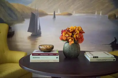 a table with books and a vase with flowers on it at InterContinental New York Barclay Hotel by IHG in New York