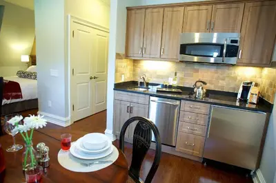 a kitchen with a table and a sink and a microwave at Norwalk Inn & Conference Center in Norwalk