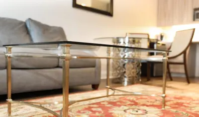 a living room with a glass table and a couch at Norwalk Inn & Conference Center in Norwalk