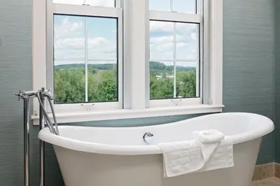 a bath tub in a bathroom with two windows at The Westin Governor Morris, Morristown in Morristown