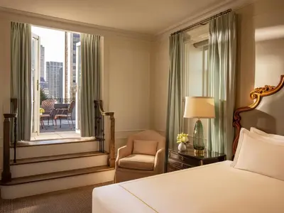 a bedroom with a bed and a chair and a window at The Plaza in New York