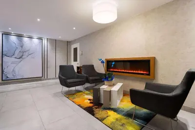 a waiting room with chairs and a fireplace at Ramada by Wyndham Bronx in Bronx