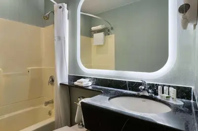 a bathroom with a sink and a mirror at Ramada by Wyndham Bronx in Bronx