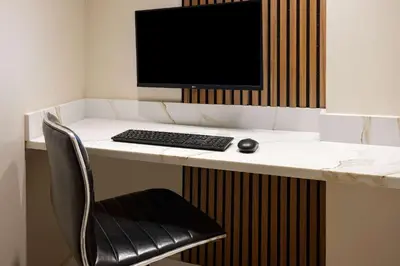 a desk with a computer monitor and a keyboard and mouse at Ramada by Wyndham Bronx in Bronx