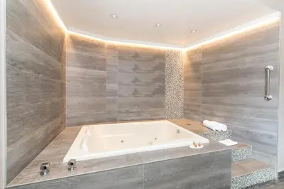 a bathroom with a bath tub in a room at Ramada by Wyndham Bronx in Bronx