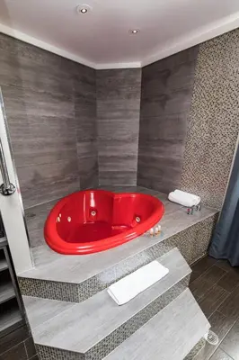 a red bath tub sitting in a bathroom at Ramada by Wyndham Bronx in Bronx