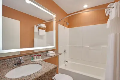 a bathroom with a sink and a tub and a shower at Ramada by Wyndham Bronx in Bronx