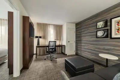 a hotel room with a desk and a chair at Residence Inn by Marriott Albany Washington Avenue in Albany