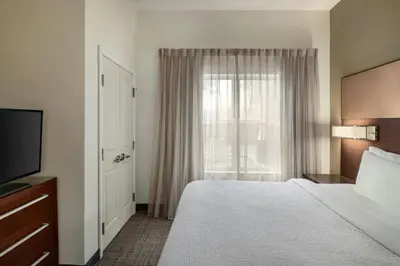 a hotel room with a bed and a window at Residence Inn by Marriott Albany Washington Avenue in Albany