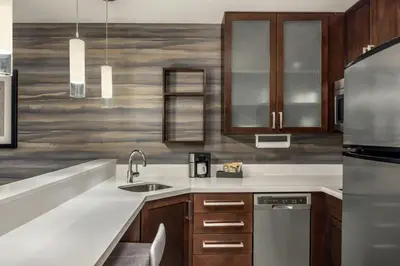 a kitchen with wooden cabinets and stainless steel appliances at Residence Inn by Marriott Albany Washington Avenue in Albany