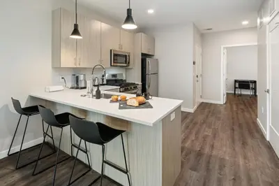 a kitchen with a counter and stools in a room at Luxury Furnished Apartments by Hyatus Downtown at Yale in New Haven
