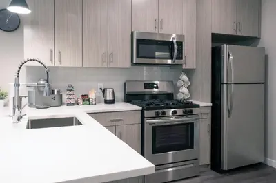 a kitchen with a stainless steel refrigerator and microwave at Luxury Furnished Apartments by Hyatus Downtown at Yale in New Haven