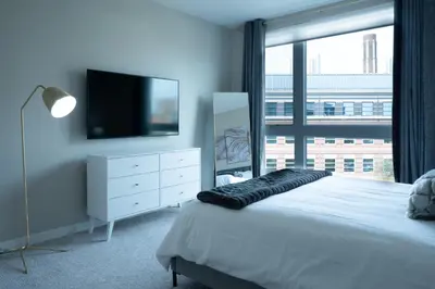 a bedroom with a flat screen tv and a bed at Luxury Furnished Apartments by Hyatus Downtown at Yale in New Haven