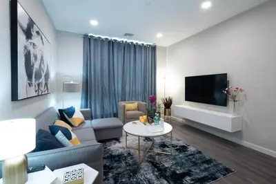 a living room with a couch and a tv at Luxury Furnished Apartments by Hyatus Downtown at Yale in New Haven