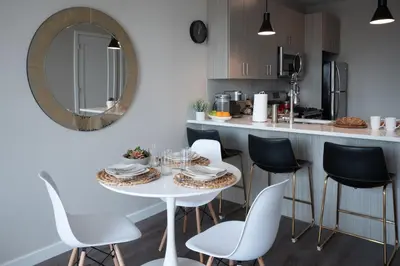 a kitchen with a white table and chairs and a mirror at Luxury Furnished Apartments by Hyatus Downtown at Yale in New Haven