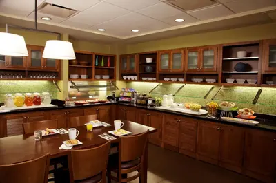 a large kitchen with a table and chairs in it at Hyatt Place Milford/New Haven in Milford