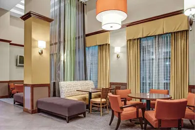 a waiting room with tables and chairs and windows at Hyatt Place Milford/New Haven in Milford