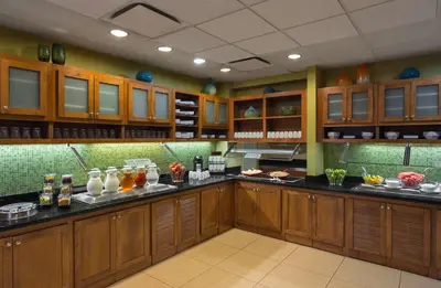 a kitchen with wooden cabinets and a counter with food at Hyatt Place Milford/New Haven in Milford