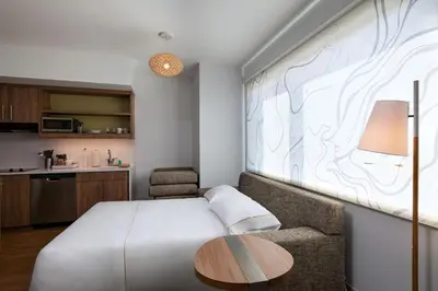 a bedroom with a bed and a table and a chair at Element Spring Valley in Spring Valley