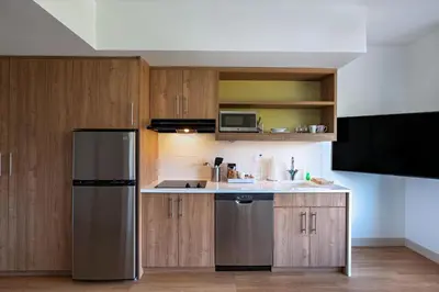 a kitchen with wooden cabinets and a stainless steel refrigerator at Element Spring Valley in Spring Valley