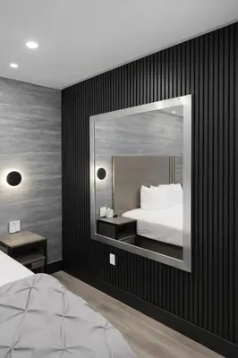 a bedroom with a bed and a large mirror at Cabana Hotel Yankee Stadium in Bronx