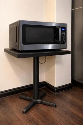 a microwave sitting on a shelf in a room at Cabana Hotel Yankee Stadium in Bronx