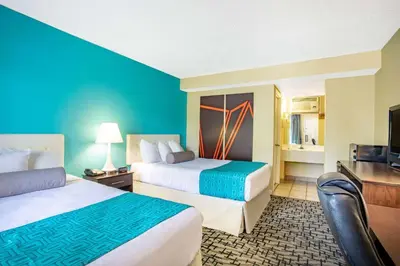 a hotel room with two beds and a flat screen tv at Howard Johnson by Wyndham Rocky Hill in Rocky Hill