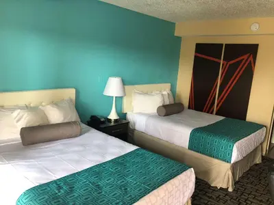 two beds in a hotel room with blue walls at Howard Johnson by Wyndham Rocky Hill in Rocky Hill