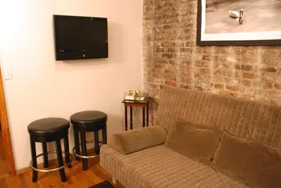 a living room with a couch and two stools at Off SoHo Suites Hotel in New York