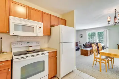 a kitchen with a white refrigerator and a table at Homey Windham Condo Hike and Ski the Catskill Mtns! in Windham