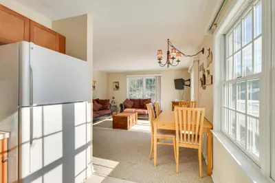 a kitchen and dining room with a refrigerator and a table at Homey Windham Condo Hike and Ski the Catskill Mtns! in Windham