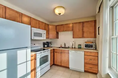 a kitchen with wooden cabinets and white appliances at Condo with Loft 2 Mi to Windham Mountain Ski! in Windham