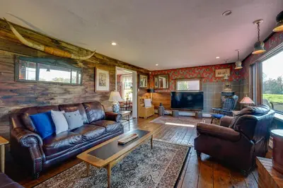 a living room with a couch and a tv at Johns Farmhouse in Mount Snow on 120 Acres! in Whitingham