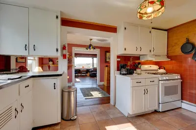 a kitchen with white cabinets and a stove top oven at Johns Farmhouse in Mount Snow on 120 Acres! in Whitingham