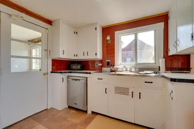 a kitchen with white cabinets and a window at Johns Farmhouse in Mount Snow on 120 Acres! in Whitingham