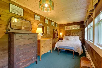 a bedroom with a bed and a dresser and a mirror at Johns Farmhouse in Mount Snow on 120 Acres! in Whitingham