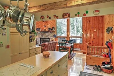a kitchen with wood paneling and a dining room at Stamford Lakefront Home with Dock and Wraparound Deck! in Stamford