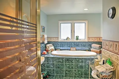 a bathroom with a tub and two sinks and a window at Stamford Lakefront Home with Dock and Wraparound Deck! in Stamford