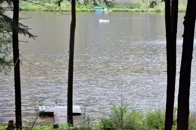 a boat in the middle of a body of water at Stamford Lakefront Home with Dock and Wraparound Deck! in Stamford